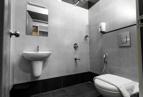 a bathroom with a toilet and a sink at Sapphire Club Metro in Ernakulam