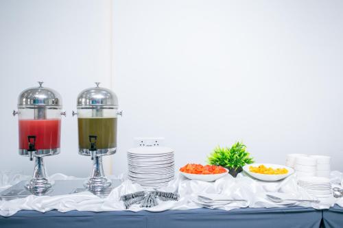 a table with two blenders and plates and bowls of food at Sapphire Club Metro in Ernakulam