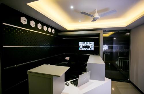 a room with a desk with a laptop on it at Sapphire Club Metro in Ernakulam