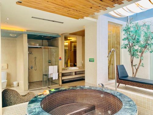 a large bathroom with a tub and a shower at Her Home Spa Motel Chiayi in Chiayi City