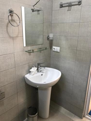a bathroom with a sink and a mirror at Hotel CHARLI in Gonio