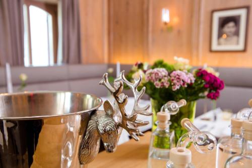a table with a bowl and a antler trophy on it at Hotel St. Florian in Frauenau