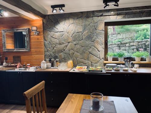 - une cuisine avec une table et un mur en pierre dans l'établissement Willa Karkonoska, à Karpacz