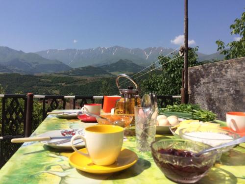 a table with a cup and plates of food on it at Ana-Maria Bnb in Tatʼev