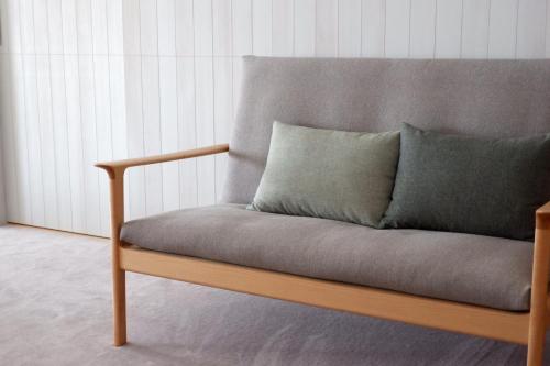 a couch with two pillows on it in a room at 滔々 御崎 二階の宿 toutou Onzaki Nikai no Yado in Kurashiki