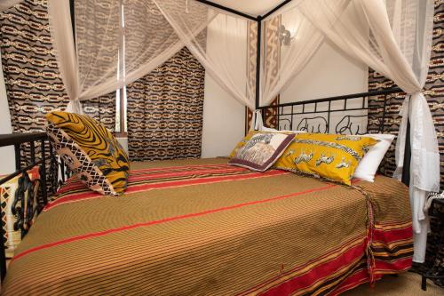ein Schlafzimmer mit einem Himmelbett in der Unterkunft Korona House Hotel in Arusha