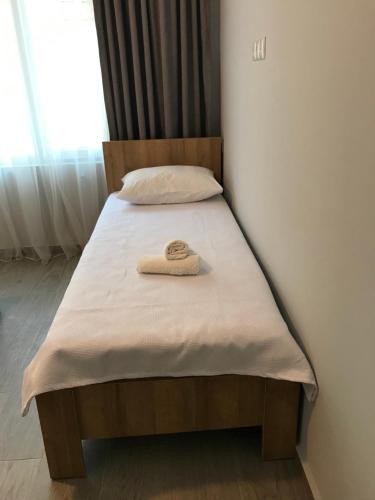 a bed with a towel sitting on top of it at Hotel CHARLI in Gonio