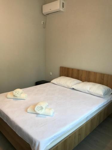 a bedroom with a bed with towels on it at Hotel CHARLI in Gonio