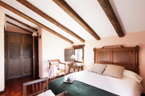 1 dormitorio con cama blanca y mesa verde en La Pizarra Negra en Campillejo