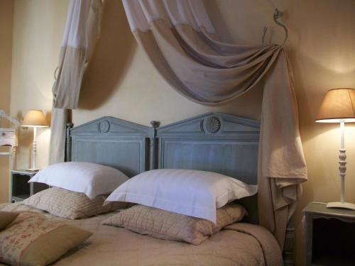 a bed with a blue headboard and two pillows at Un Patio en Luberon in Ansouis