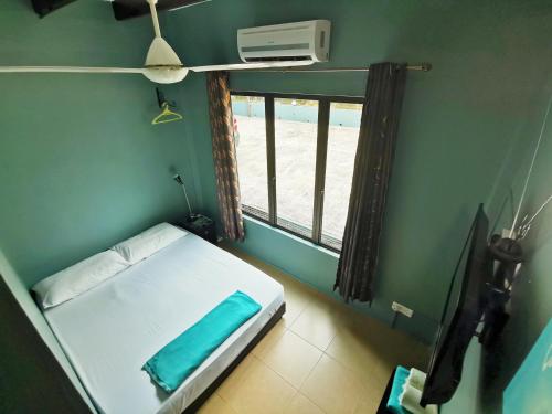 a small room with a bed and a window at Green Peace Sungai Lembing in Sungai Lembing