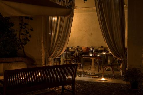 a dark room with a bench and a table with chairs at La Barchessa di Villa Pisani in Lonigo