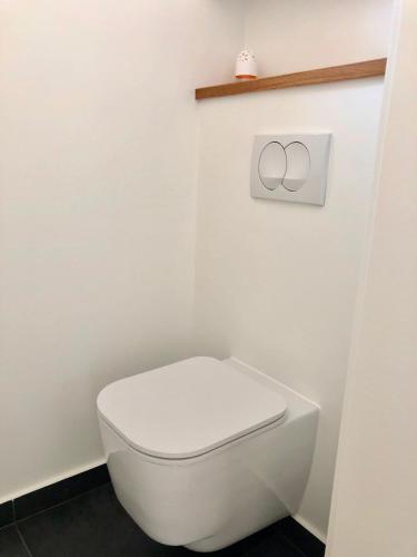 a bathroom with a white toilet with a symbol on the wall at Villa Sunny Garden in Barbat na Rabu