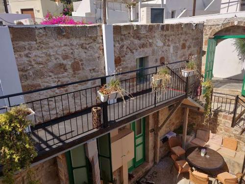 a balcony with a table and chairs and a patio at Xenones Lindos in Líndos