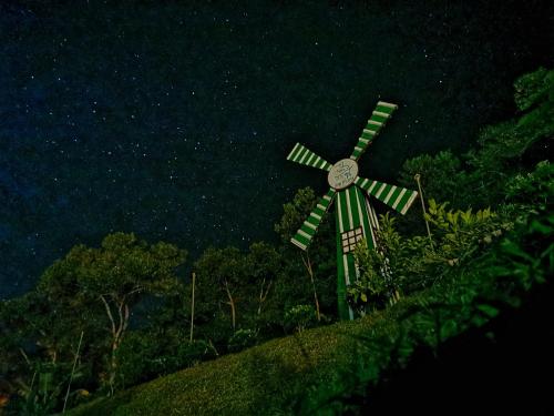 a clock on top of a windmill on a hill at night at Green Peace Sungai Lembing in Sungai Lembing