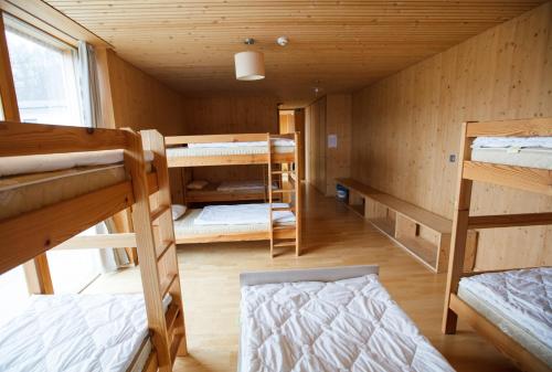 Ravne na KoroškemにあるYouth Hostel Punklのキャビン内の二段ベッド数組が備わる客室です。