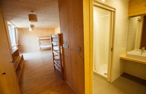 Habitación con baño con lavabo y escalera. en Youth Hostel Punkl en Ravne na Koroškem