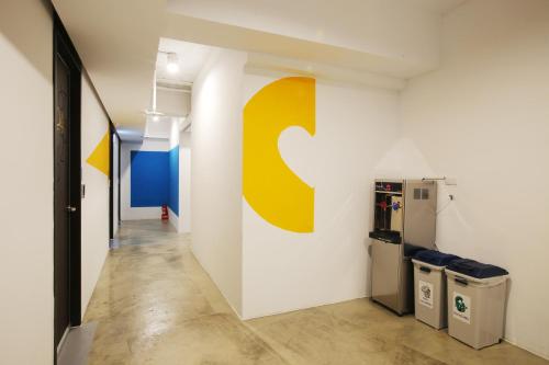 a kitchen with a refrigerator, sink, and trashcan at Loosha Hostel in Taichung