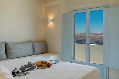 a bedroom with a bed with a plate of fruit on it at Akrorama private villas and suites in Akrotiri