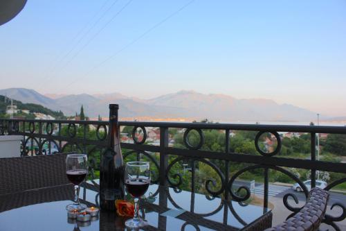 a table with two glasses of wine on a balcony at Villa Julia in Baošići