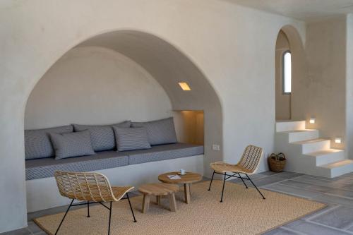 a room with a bench with two chairs and a table at Akrorama private villas and suites in Akrotiri