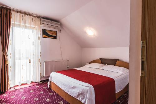 sypialnia z dużym łóżkiem i czerwonym kocem w obiekcie Raza de Soare w mieście Breaza