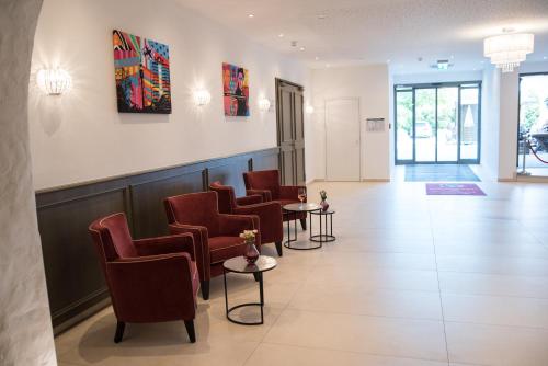 a waiting room with a row of chairs and tables at Hotel Räucherhansl in Loiching
