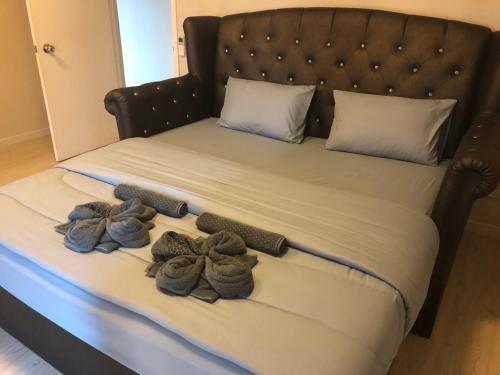 a bed with three pairs of mens shoes on it at The 21 MuangthongThani in Pak Kret