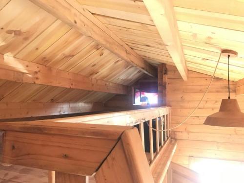 une cabane en bois avec un plafond avec une lumière dans l'établissement un Chalet avec jardin à 1km de la mer, à Saint-Froult