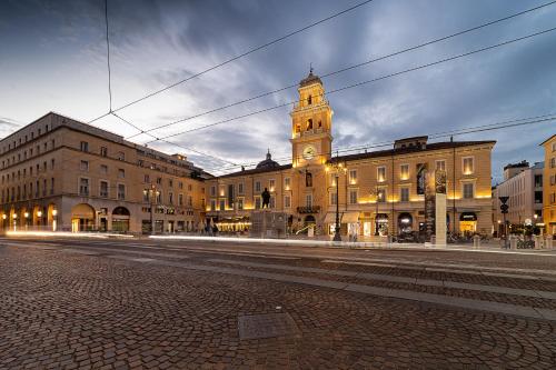 een groot gebouw met een klokkentoren op een straat bij Hotel Button in Parma