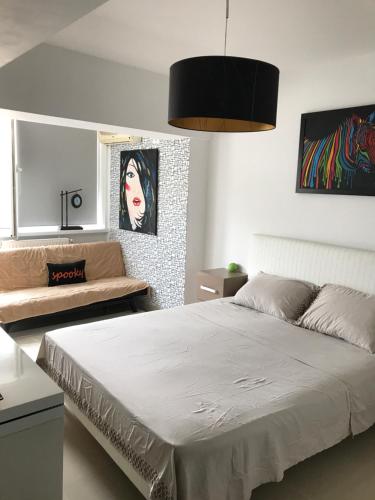 a bedroom with a large bed and a couch at Ozana apartament in Constanţa
