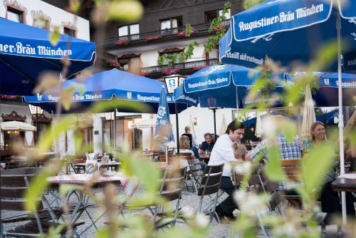 a group of people sitting at tables under umbrellas at Hotel Räucherhansl in Loiching