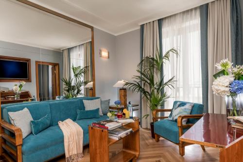 a living room with a blue couch and a table at Bettoja Hotel Mediterraneo in Rome