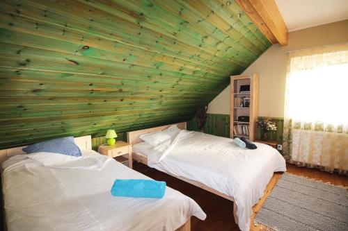 a bedroom with two beds and a wooden wall at Põhja Tooma Holiday Houses in Suuresadama