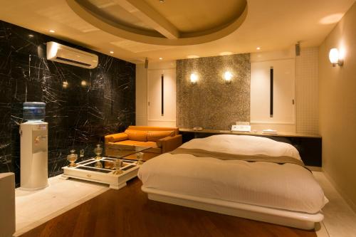 a bedroom with a bed and a chair in a room at Hotel Kilala (Adult Only) in Koriyama