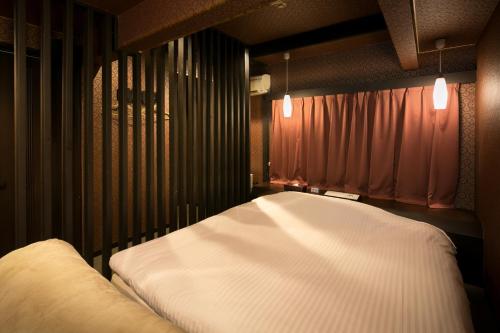 a bedroom with a large white bed in it at Hotel Kilala (Adult Only) in Koriyama