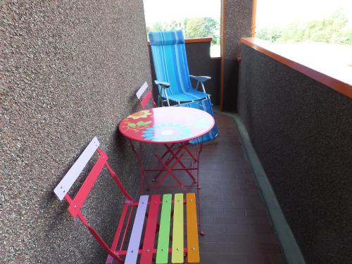 two colorful chairs and a table next to a wall at B&B Partenza Funivia in Lecco