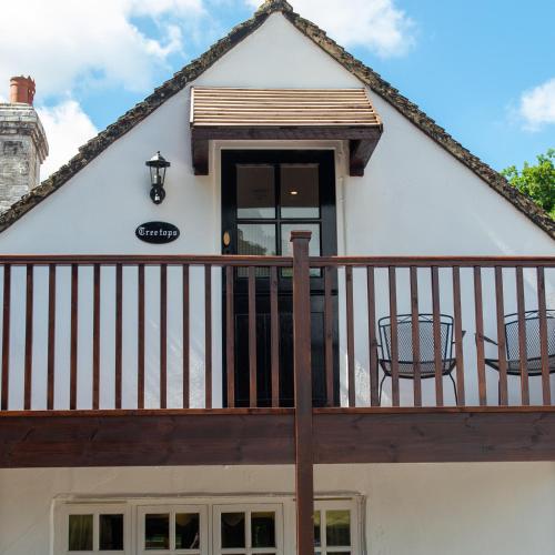 a house with a balcony with two chairs at The Withies Inn in Godalming