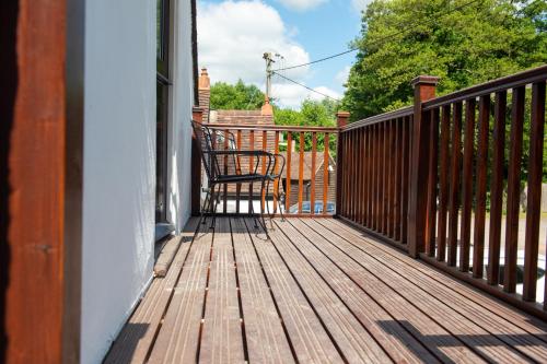 a wooden deck with a chair on a porch at The Withies Inn in Godalming