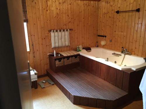 Cette chambre dispose de murs en bois et d'une grande baignoire. dans l'établissement Gîte la Treille, à Cholet