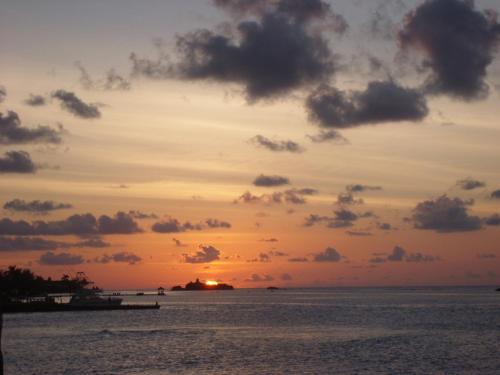 a sunset over the ocean with a pier at Triplets on the Bay in Montego Bay