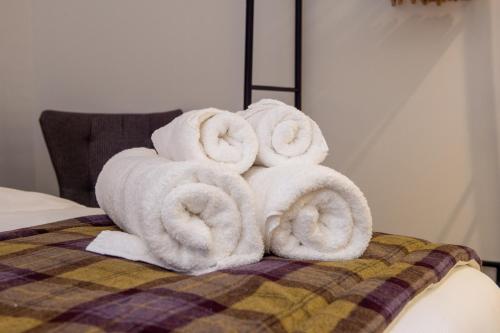 a pile of towels sitting on top of a bed at The Withies Inn in Godalming