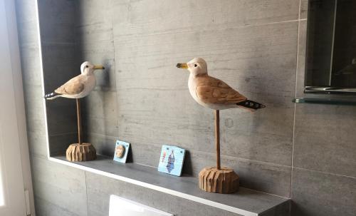 two statues of birds on a shelf in a bathroom at Sea View Kozino in Kožino