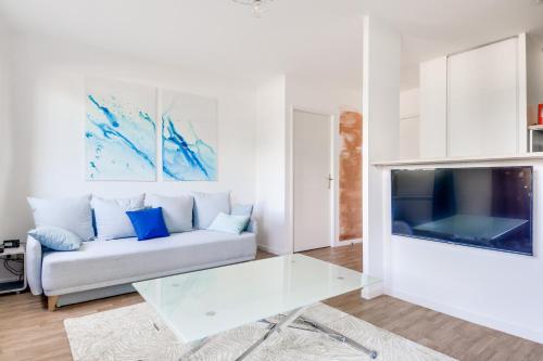 un salon avec un canapé et une télévision dans l'établissement Water Color - SDP, à Magny-le-Hongre