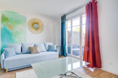 un salon avec un canapé et une table en verre dans l'établissement Water Color - SDP, à Magny-le-Hongre