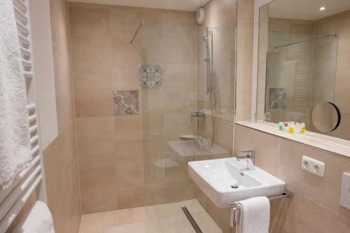 a bathroom with a sink and a shower at Hotel Räucherhansl in Loiching