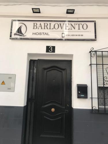 a black door to a building with a sign above it at Pensión Barlovento in Málaga