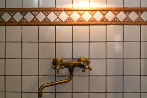 - un tuyau sur un mur carrelé dans la salle de bains dans l'établissement Cosy Cottage, à Florence
