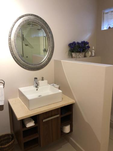a bathroom with a sink and a mirror at Plettenberg Bay Getaway in Plettenberg Bay