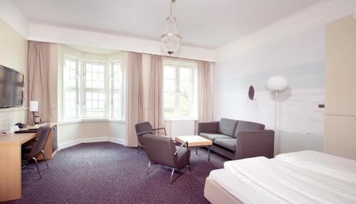 a hotel room with a bed and a desk at Clarion Collection Hotel Savoy in Oslo